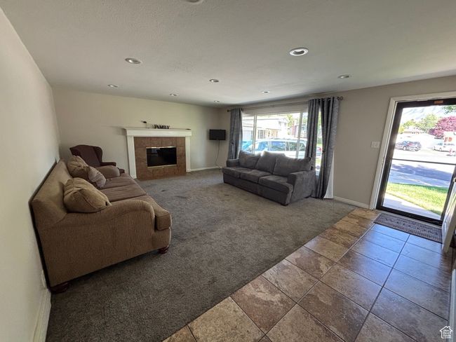 Carpeted living room with a tile fireplace, baseboards, and recessed lighting | Image 8