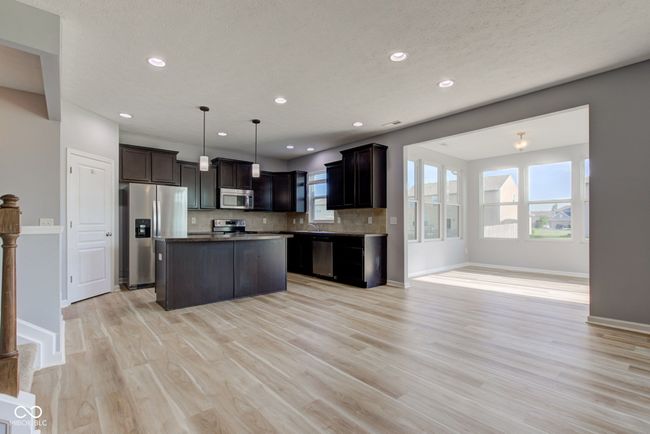 kitchen with appliances with stainless steel finishes, light wood-type flooring, recessed lighting, a center island, and decorative backsplash | Image 5