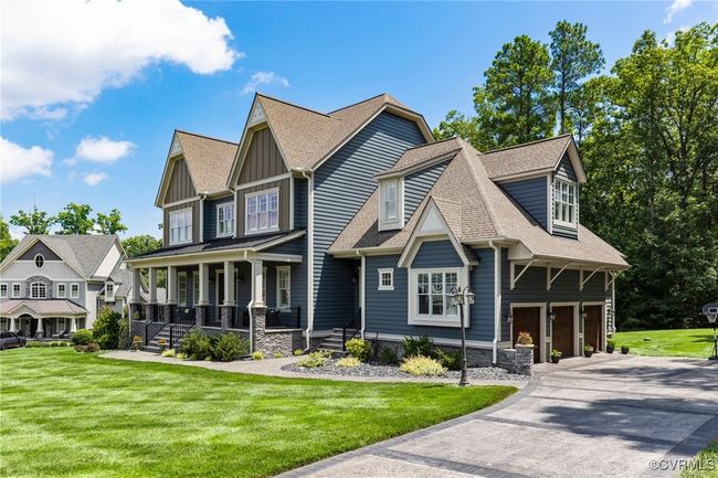 View of front facade featuring a porch, concrete driveway, a garage, and a front lawn | Image 46