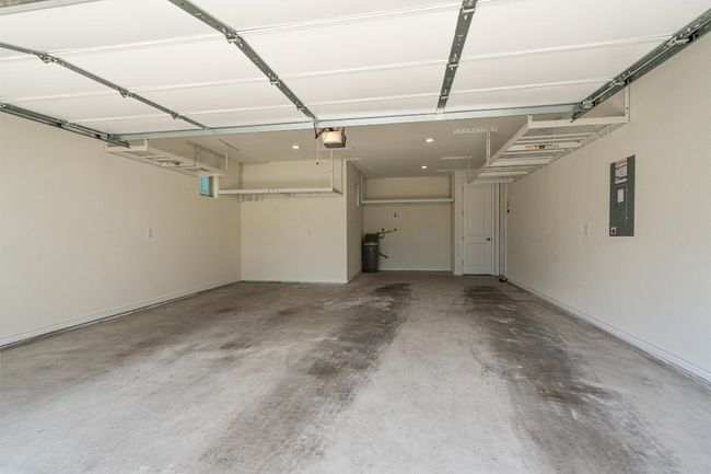 Full 2 car garage with additional space for your golf car with golf cart outlet. Water softener stays with the home. Owners have added ceiling racks for additional storage. | Image 31