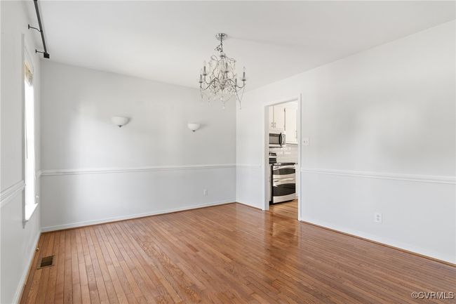 Empty room with a chandelier and hardwood / wood-style floors | Image 5