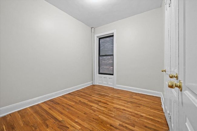 Spare room with wood finished floors and baseboards | Image 9