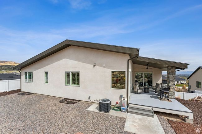 Rear view of property featuring a patio, a ceiling fan, stucco siding, and fence | Image 66