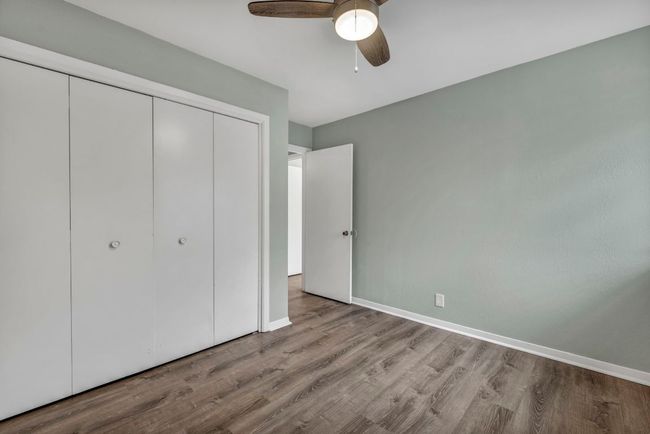 Unfurnished bedroom with wood finished floors, a closet, and baseboards | Image 16