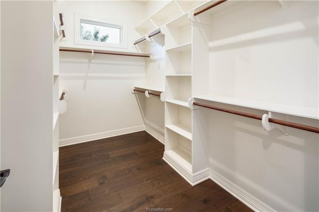 Walk in closet with dark wood finished floors | Image 25