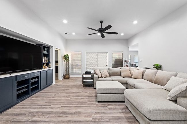 Living room featuring a bar, light wood-style flooring, recessed lighting, and a ceiling fan | Image 4