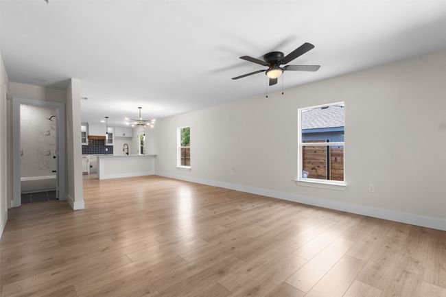 Unfurnished living room featuring a chandelier, ceiling fan, and light wood finished floors | Image 6