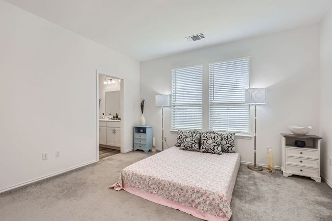 Carpeted bedroom featuring multiple windows, baseboards, and ensuite bathroom | Image 15