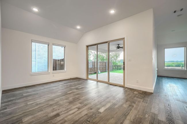 Spare room with healthy amount of natural light, lofted ceiling, dark wood-type flooring, baseboards, and recessed lighting | Image 13