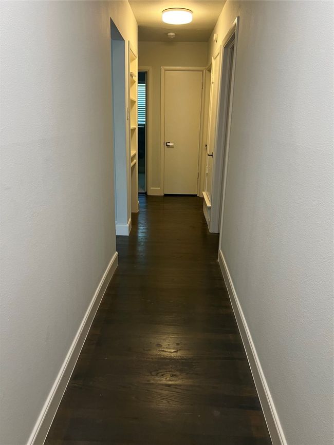 Hallway from primary bedroom to guest bedrooms to the right and to kitchen on left | Image 15