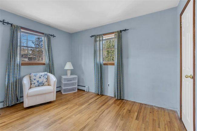 Living area featuring baseboard heating and hardwood / wood-style flooring | Image 18