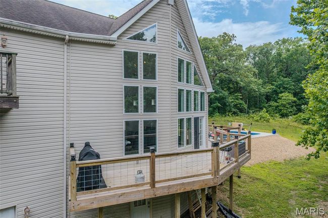 Rear view of property featuring a deck, a shingled roof, and a lawn | Image 70