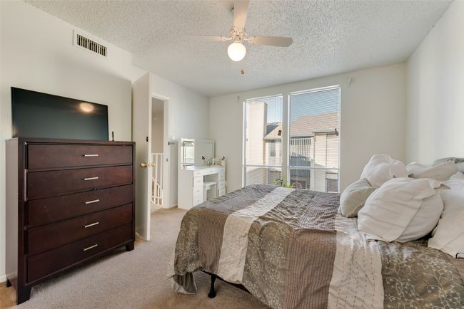 Carpeted bedroom featuring ceiling fan and a textured ceiling | Image 13