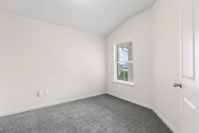 Carpeted spare room featuring lofted ceiling and baseboards | Image 6