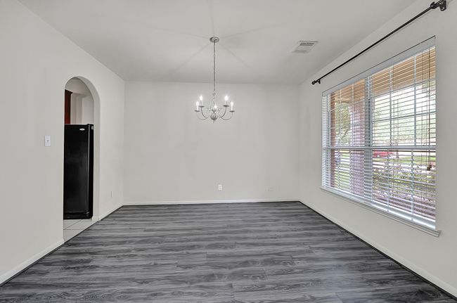 Additional dining room view showcasing the large window allowing plenty of natural light to fill the space and the arched doorway for easy access to the kitchen. | Image 4