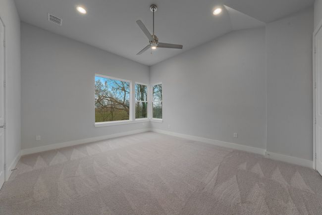 Spare room with vaulted ceiling, a ceiling fan, visible vents, and carpet | Image 21