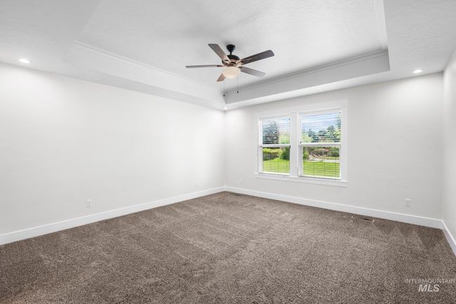 Unfurnished room with a raised ceiling, ornamental molding, ceiling fan, carpet floors, and recessed lighting | Image 25