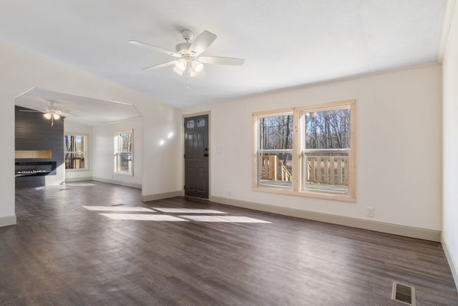 The family room and living room are connected yet distinct, with a partial wall adding just the right amount of separation. From this vantage point, you can still enjoy the cozy glow of the fireplace, making the space feel warm and inviting | Image 8