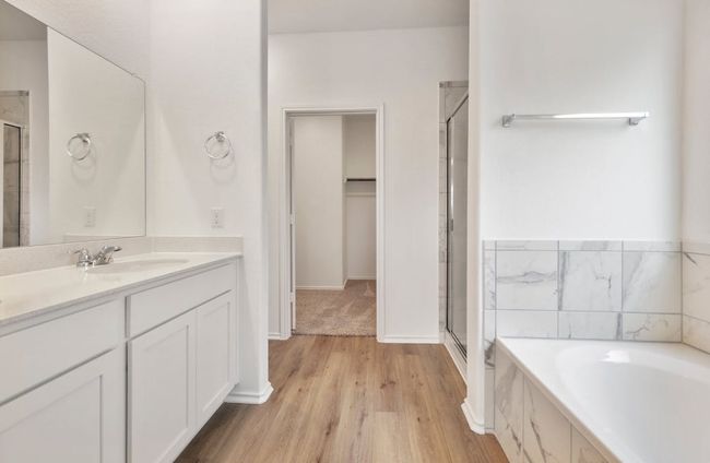 Full bathroom featuring a stall shower, vanity, a garden tub, and wood finished floors | Image 22