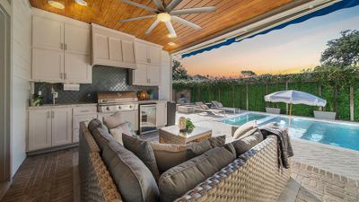 You may never have to leave your home for a vacation ever again - you will have everything you need to enjoy the sun in your own backyard! Featuring a sparkling pool & spa, outdoor kitchen, cozy fire pit, outdoor shower, turfed area & a motorized SunSetter awning. | Image 1