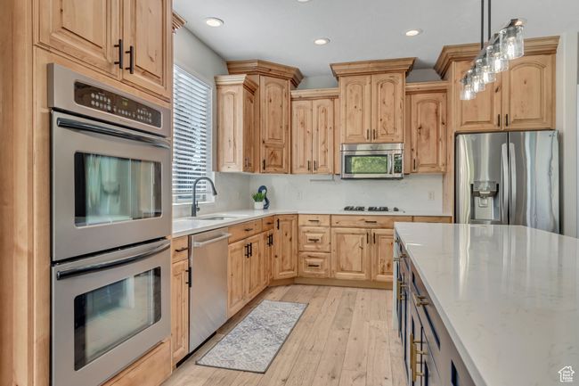 Kitchen with appliances with stainless steel finishes, light brown cabinets, light wood-type flooring, pendant lighting, and recessed lighting | Image 9