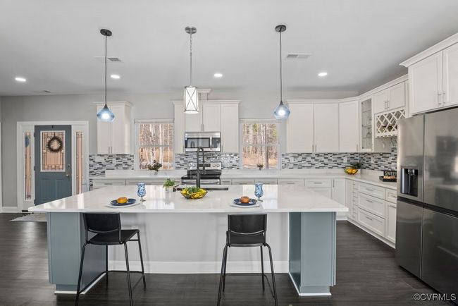 Kitchen featuring a breakfast bar, granite countertops, plenty of natural light, and appliances with stainless steel finishes | Image 7