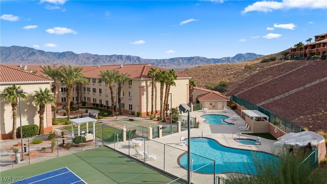 Community pool with a mountain view, fence, a patio, and a hot tub | Image 51
