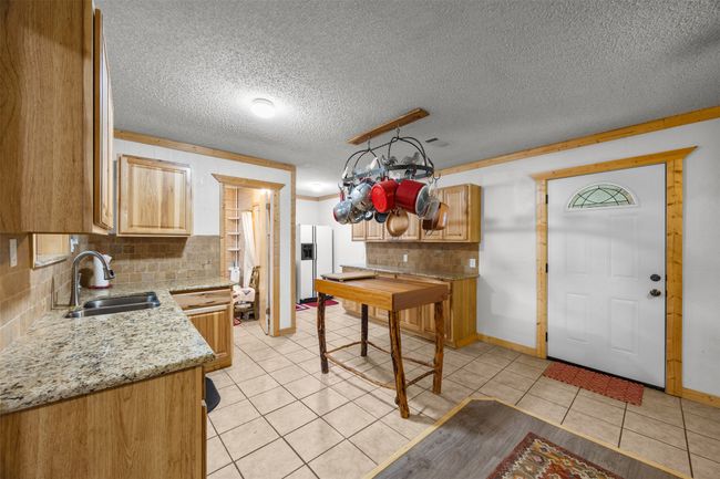 Kitchen with updated granite and backsplash, tile flooring. | Image 8