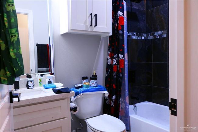 Full bathroom featuring toilet, vanity, and shower / tub combo with curtain | Image 19