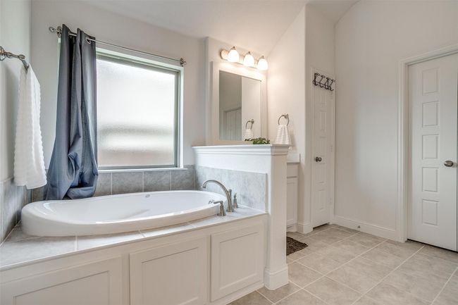 Bathroom featuring healthy amount of natural light, a garden tub, and tile patterned flooring | Image 26