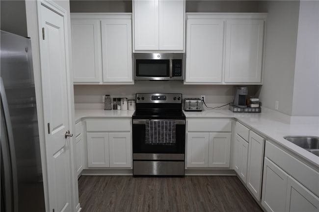 Kitchen with appliances with stainless steel finishes and white cabinetry | Image 8