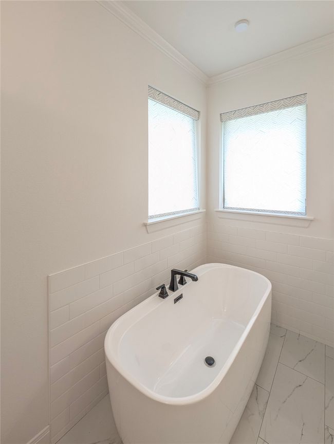 Full bath with a freestanding bath, marble finish floors, and ornamental molding | Image 20