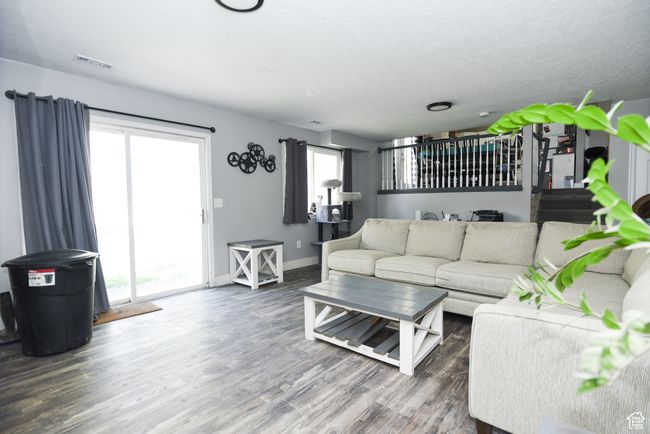 Living room with visible vents, wood finished floors, and baseboards | Image 22