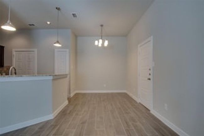Kitchen with wood finished floors, a chandelier, baseboards, and pendant lighting | Image 6
