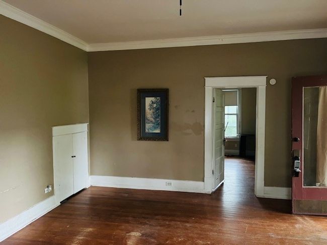 Unfurnished room with crown molding, wood-type flooring, and baseboards | Image 7