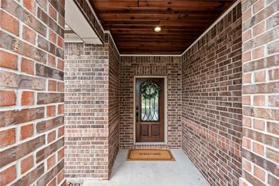 An Upscale Entry welcomes you accentuated with a Gleaming Wood Door with metal Insets. The Wood Ceiling completes the finished look and is only one of the many upgrades featured throughout this exclusive home. | Image 3