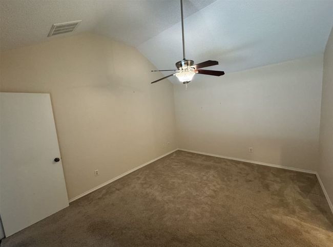 Master bedroom with ceiling fan, light tile floors, a textured ceiling, ensuite bath, and lofted ceiling | Image 11