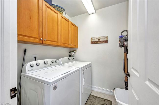 Laundry area featuring cabinet space, separate washer and dryer, and light tile patterned floors | Image 28