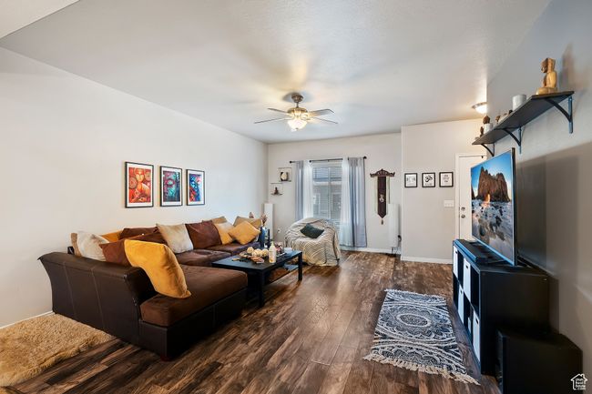 Living area with dark wood-type flooring and a ceiling fan | Image 5