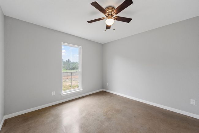 Unfurnished room featuring baseboards, a ceiling fan, and concrete flooring | Image 9