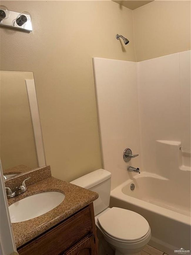 Bathroom featuring toilet, shower / bathtub combination, vanity, and tile patterned flooring | Image 6
