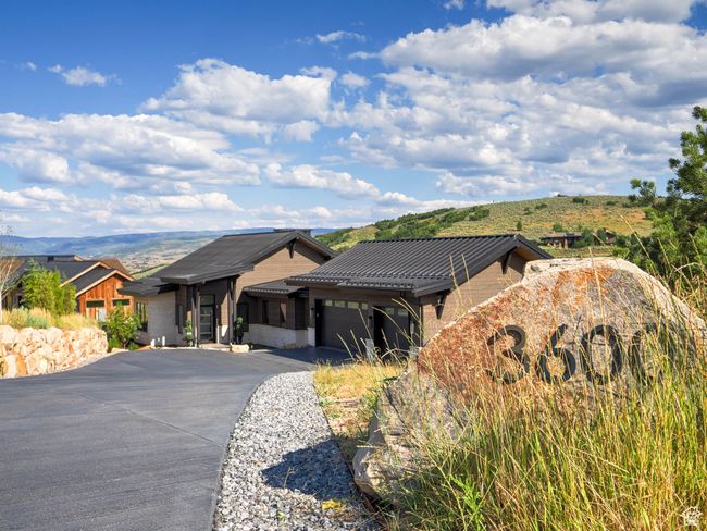 View of front of home with a garage, driveway, a metal roof, and a mountain view | Image 4