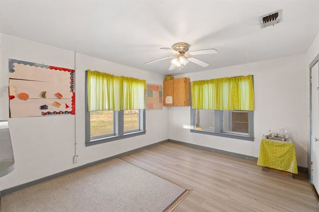 Spare room featuring visible vents, baseboards, wood finished floors, and a ceiling fan | Image 24