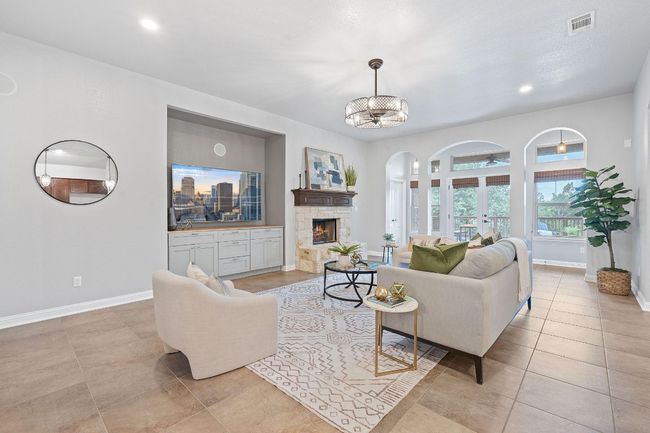 Living area with arched walkways, baseboards, a fireplace, tile flooring, and recessed lighting | Image 7
