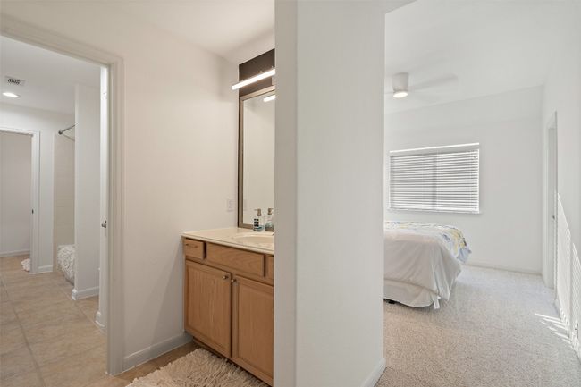 Ensuite bathroom featuring vanity, ensuite bath, walk in shower, baseboards, and ceiling fan | Image 21