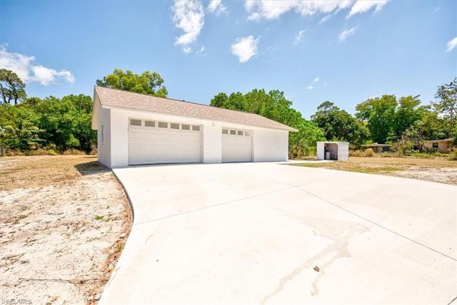 View of front of property with a detached garage, an outdoor structure, and stucco siding | Image 45