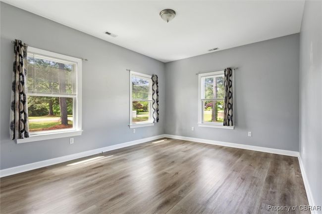 Spare room with wood finished floors and baseboards | Image 16