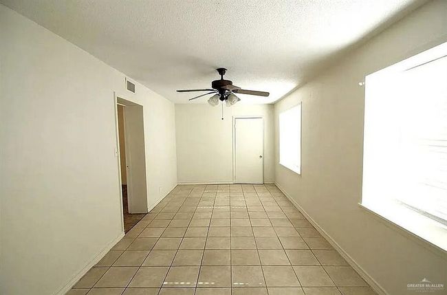 Unfurnished room featuring ceiling fan, a textured ceiling, and light tile patterned floors | Image 9