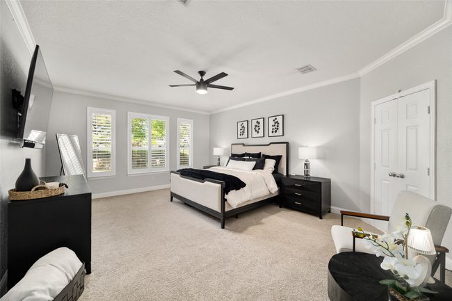 Bedroom featuring crown molding, baseboards, light carpet, and visible vents | Image 16