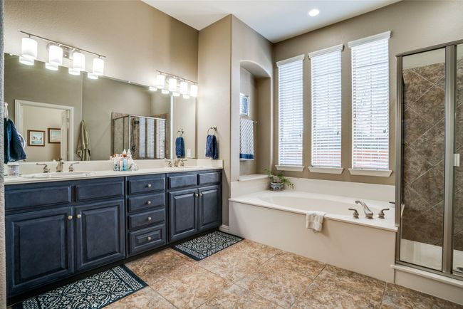 Primary bathroom featuring shower, bath, & double sinks | Image 15